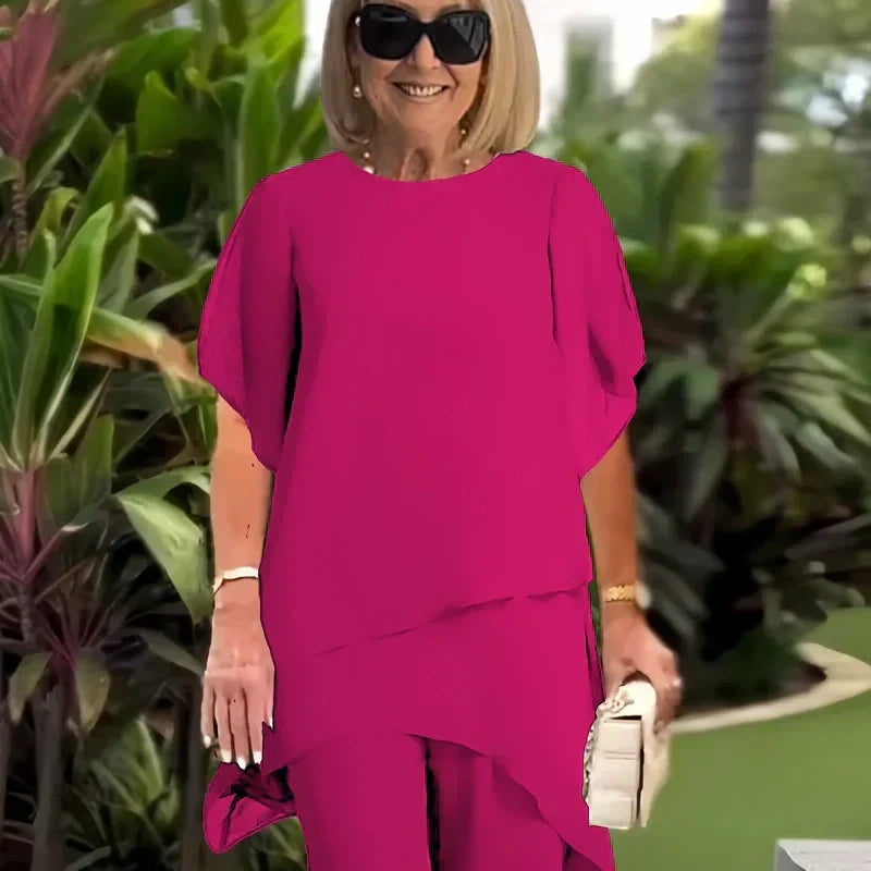 Charmerende sæt med uregelmæssig top og bukser med brede ben – asymmetrisk kant, flagrende dobbeltlag og elegance hele dagen 👗✨